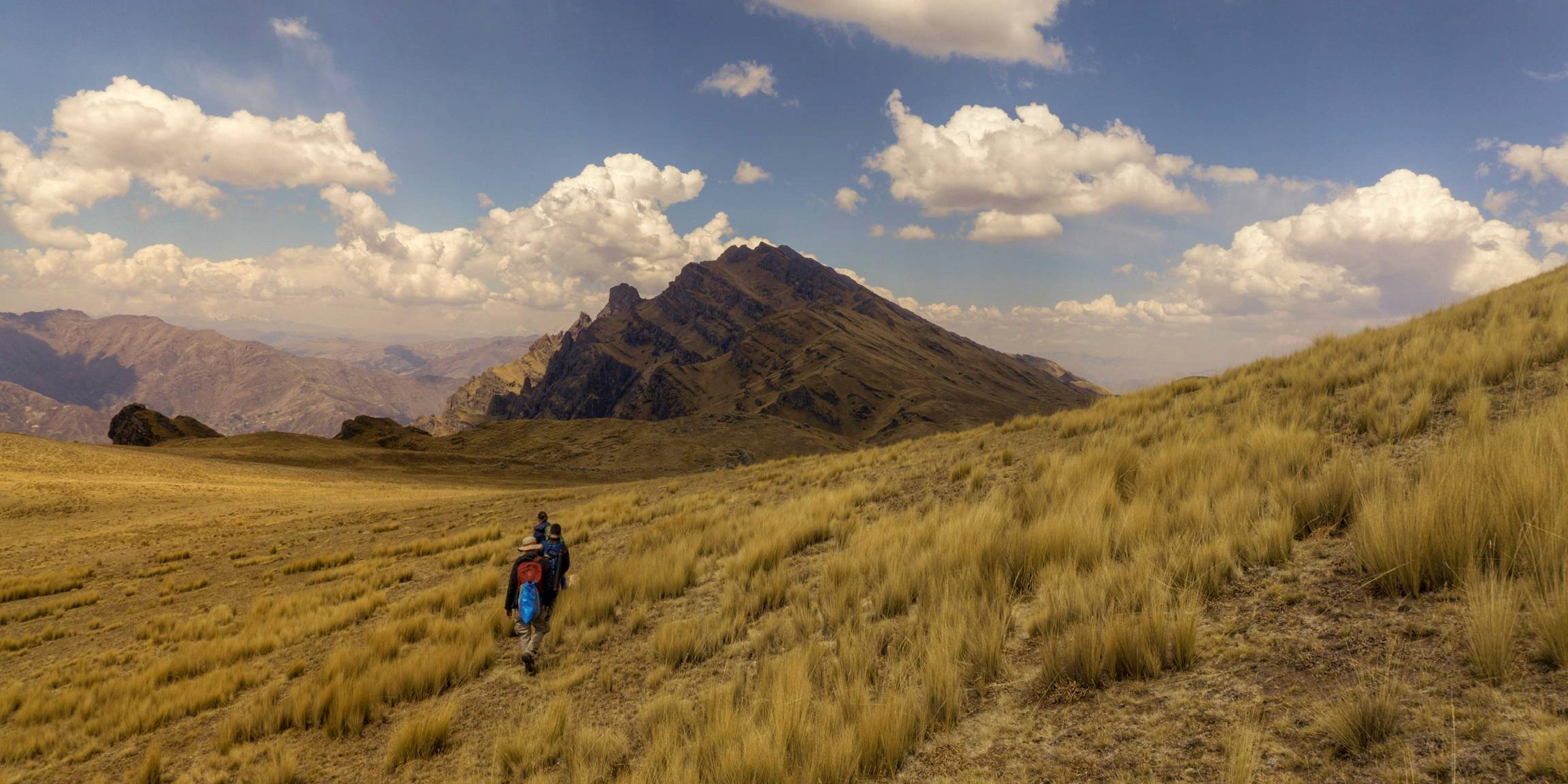 Walkers following a ridge line high above a valley.