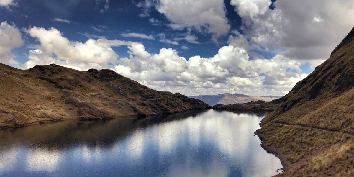 Calm water reflecting the hills that surround it.